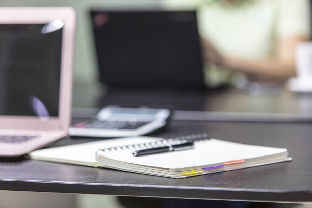 istock Laptop Computer on a Modern Wooden Business Desk with a Notepad and Pen in Unfocused Background 1407976830