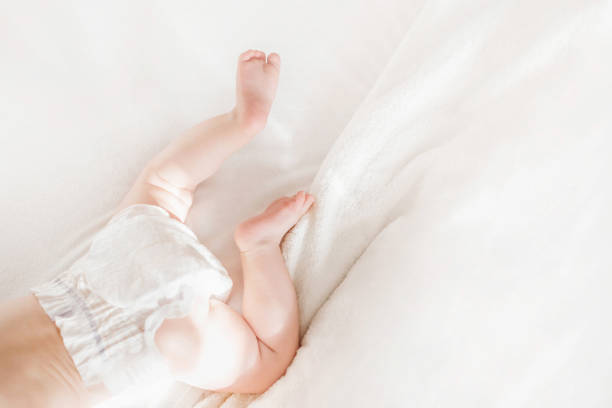istock Baby in a diaper lies on a white bed. top view. copy space 1407977159