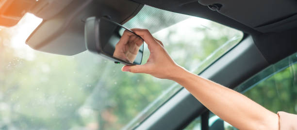 istock woman driver adjusting rear view mirror a car 1407978054