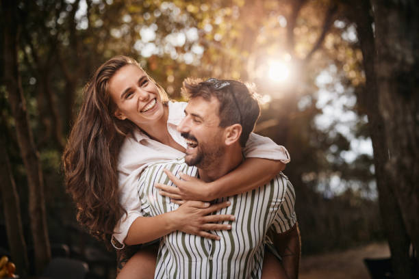 istock Cheerful couple having fun while piggybacking in nature. 1407978064