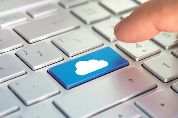 Photo of finger and button with cloud. Cloud computing concept on computer keyboard