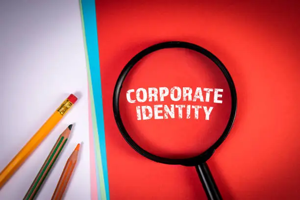 Photo of Corporate Identity. Magnifying glass and pencils on office table