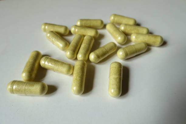 múltiplas cápsulas verdes amarelas de suplemento dietético quercetina - quercetin - fotografias e filmes do acervo