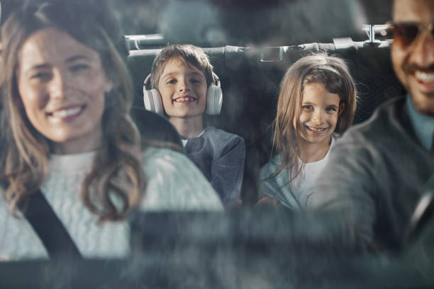 Happy kids enjoying while going on family vacation by car.