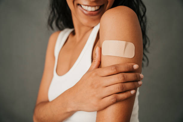 istock Close up band aid on multiethnic female arm 1407982367