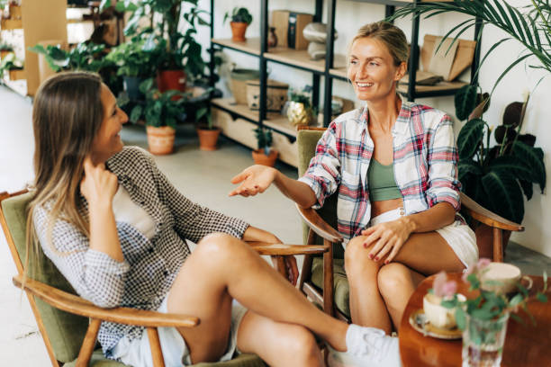 istock Two young attractive women are chatting while sitting in a cafe. 1407982763