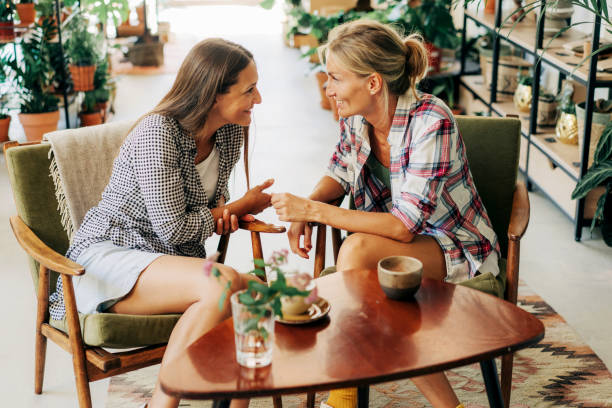 istock Two stylish female girlfriends are talking while sitting in a cafe. 1407982777
