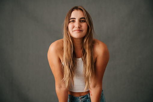 Close up Caucasian female long blond hair smiling in casual wear with her shoulders forward. High quality photo