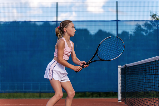Young professional sportswoman playing tennis on sport court