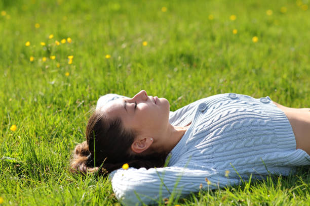 istock Woman resting lying on the grass in the mountain 1407985718