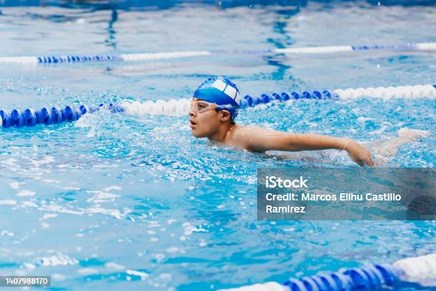Latin Child Boy Swimmer Wearing Cap And Goggles In A Swimming Training At The Pool In Mexico Latin America Stock Photo - Download Image Now