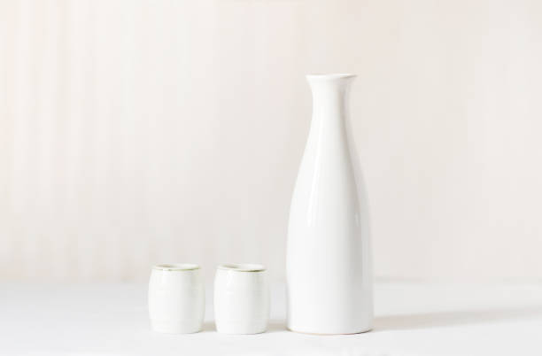 istock White vase and two white glasses on a white table. In the background is a light milky background. 1407988562