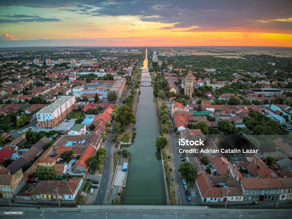 The city of Timisoara, Romania Aerial view of Bega River shore during a dramatic orange sunset. Drone photo taken on 26th of June 2022, in Timisoara, Timis county, Romania. Timisoara Stock Photo
