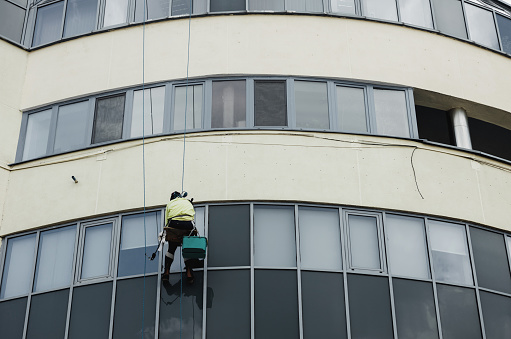 Window washer cleaning building facade. work at height. industrial mountaineering. high-rise window washing