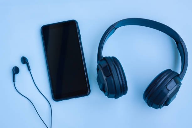 istock Smartphone,Black Headphone and Wired earphones on Blue background 1407992238