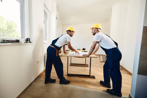 Male carpenters talking while analyzing housing project in apartment.