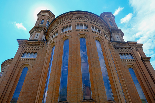 Facade of Monumental cathedral in Modena, Italy, Tempio monumentale ai Caduti di Guerra across the blue sky from beneath