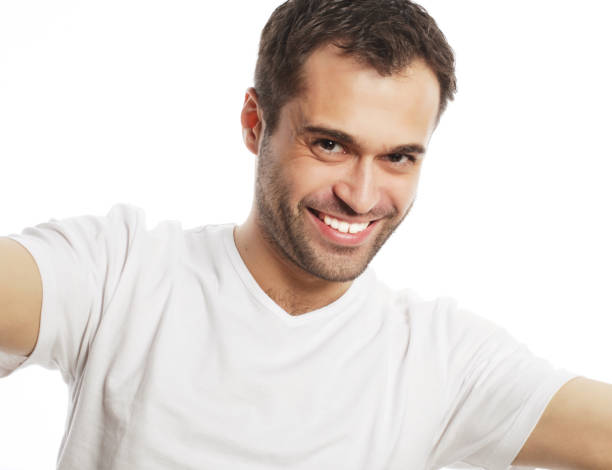 istock young man holding camera and making selfie 1407998960