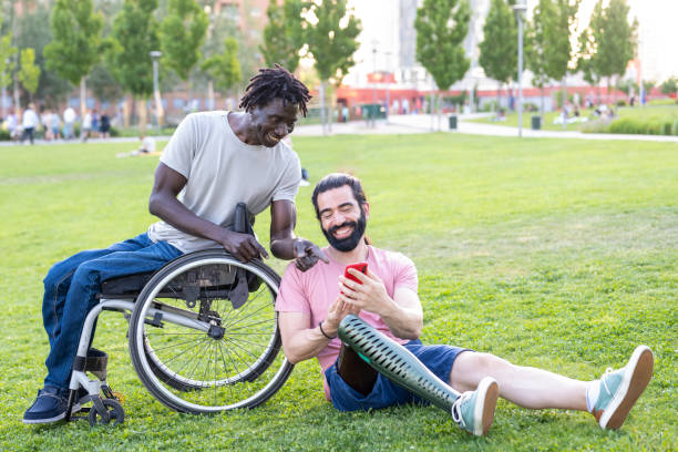 two friends with disability chatting and using smartphone outdoor, people using modern device to communicate