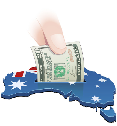 3D map of Australia in the colors of the Australian flag with a 20 dollar bill in it by a hand