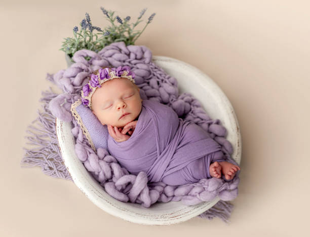 istock Newborn sleeping wrapped in violet blanket 1408004655