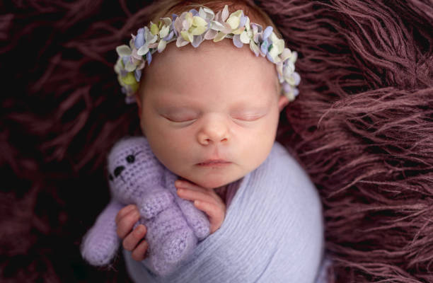 istock Newborn wearing diadem sleeping with toy 1408004672
