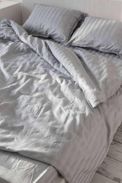 istock gray linens in sunlight on  bed in  bedroom 1408006123