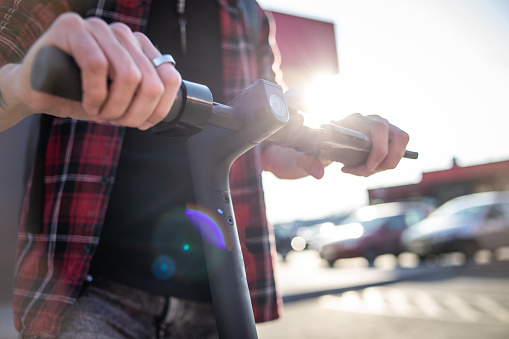 Technology, ecological concept of mobility. Hipster young man driving an electric scooter