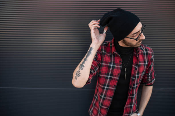 istock A hipster young man leaning against a gray wall 1408006851