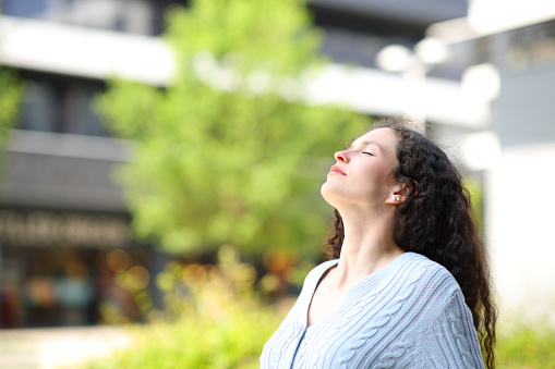 Woman breathing fresh air in the street