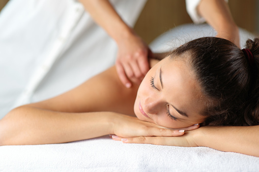 Mujer relajándose con terapeuta masajeando en spa photo