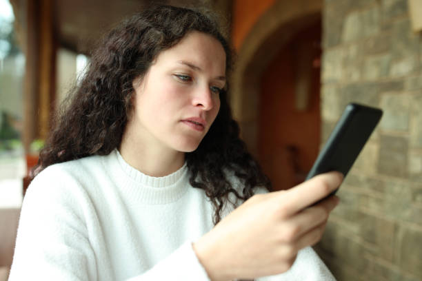 istock Woman checking phone in a restaurant 1408009010