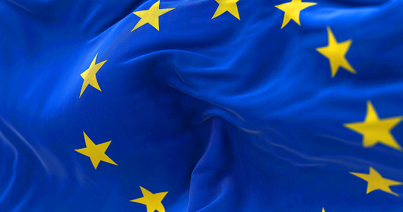 Close-up view of the European Union flag waving in the wind. The European Union is a political and economic union of 27 member states that are located primarily in Europe