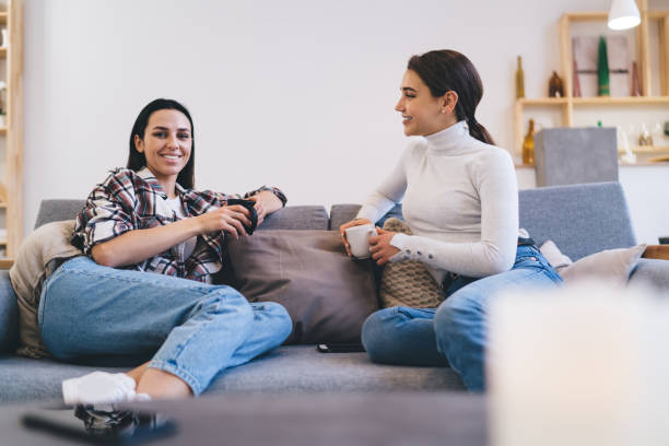 istock Cheerful friends chilling on couch together 1408009143