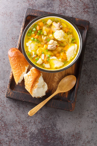 istock Chicken broth with vegetables and dumplings close-up in a bowl. Vertical top view 1408009233