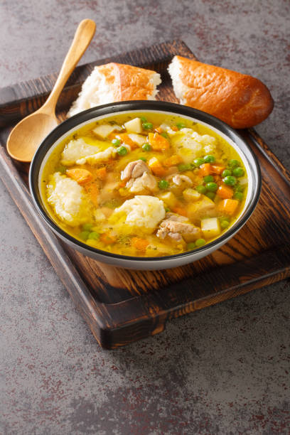 istock Chicken broth with vegetables and dumplings close-up in a bowl. Vertical 1408009385
