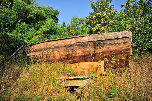 Dilapidated boats parked under the green bushes near village Achara district Sindhudurga state Maharashtra india