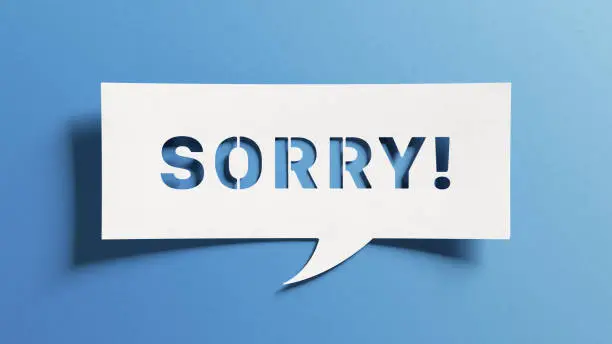 Photo of Sorry message to express regret, remorse, apology for error, mistake, guilt and request forgiveness. Concept with word written in cut out paper in shape of speech bubble with blue background.