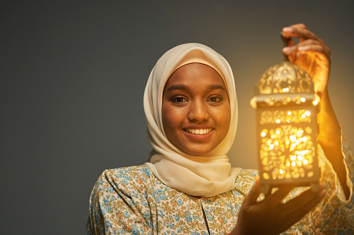 malay hijab with traditional clothing holding arabic lantern celebrating ramadan