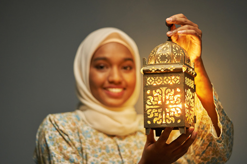 hijab malayo con ropa tradicional sosteniendo una linterna árabe que celebra el Ramadán photo