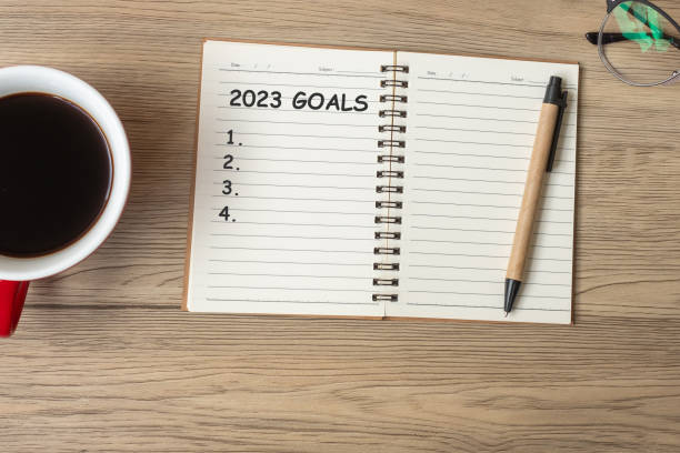 istock 2023 GOAL with notebook, black coffee cup and pen on wood table, Top view and copy space. Happy New Year, Resolution, To do list, Strategy and Plan concept 1408017876