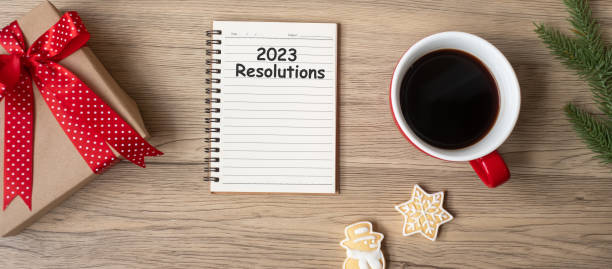 istock 2023 Resolutions with notebook, black coffee cup, Christmas cookies and pen on wood table, Top view and copy space. Xmas, Happy New Year, Goals, To do list, Strategy and Plan concept 1408018552