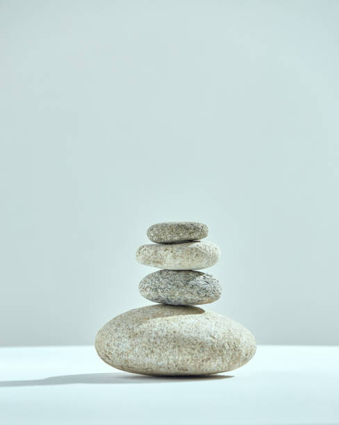 Pyramid of stacked stones. Small tower of rocks. Cairns of four pebbles. Harmony, zen, balance concept. Copy space Pyramid of stacked stones. Small tower of rocks. Cairns of four pebbles. Harmony, zen, balance concept. Copy space. High quality photo cairn stock pictures, royalty-free photos & images