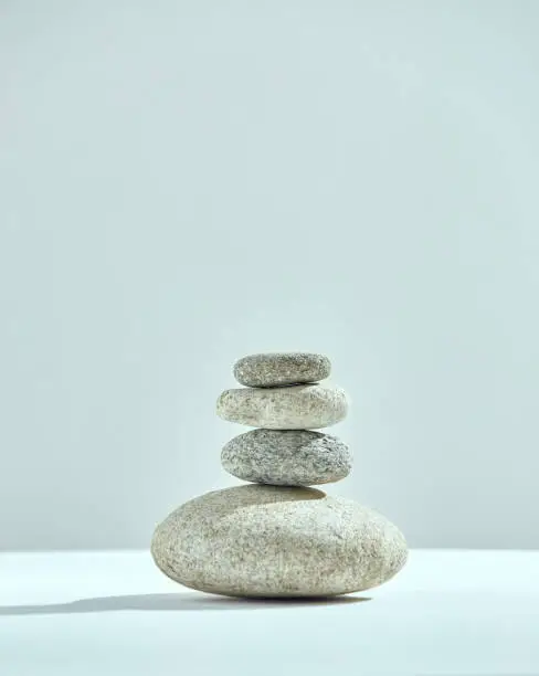 Photo of Pyramid of stacked stones. Small tower of rocks. Cairns of four pebbles. Harmony, zen, balance concept. Copy space