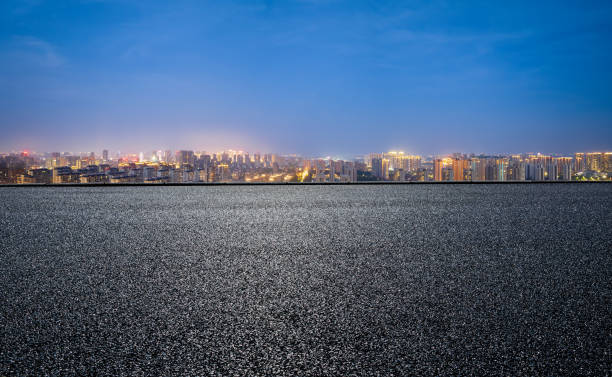 istock Asphalt road and city skyline with building scenery at night 1408021089