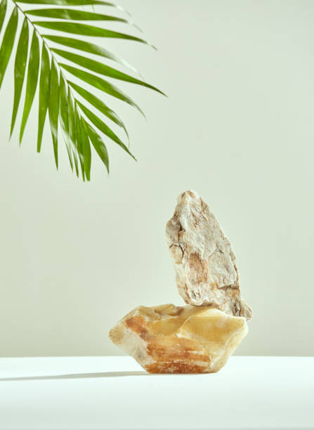 istock Empty stone podium for cosmetics advertisement. Stones pedestal, green palm leaf. Mockup for product presentation 1408021165
