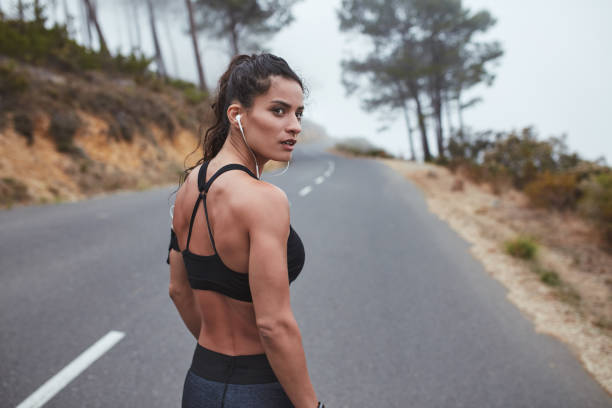 istock Female runner standing on a road in the morning 1408021839
