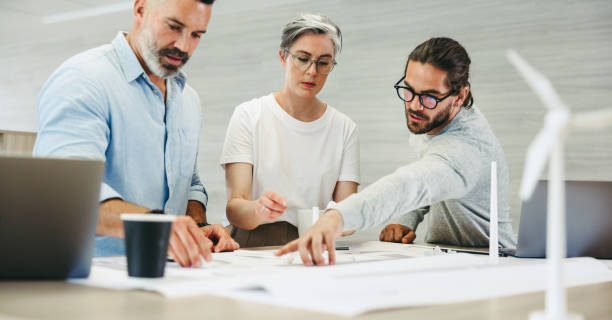 istock Group of creative designers working with wind turbine blueprints 1408022276