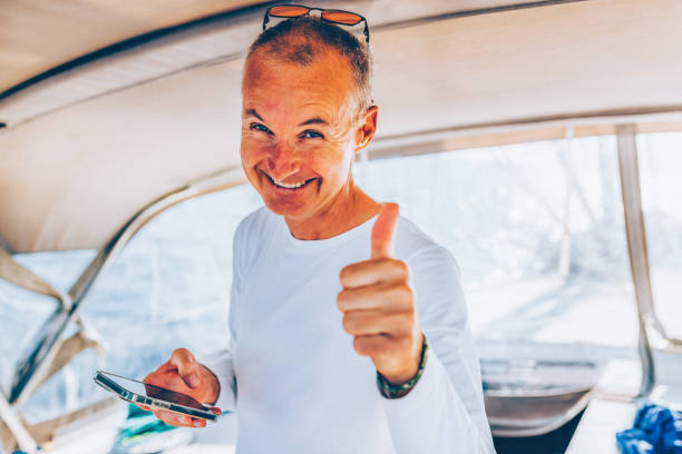 Businessman working with smart phone on sailboat.