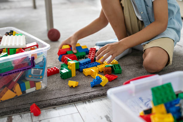 istock Little toddler boy playing with colorful plastic blocks at home building creative game, imagination 1408022801